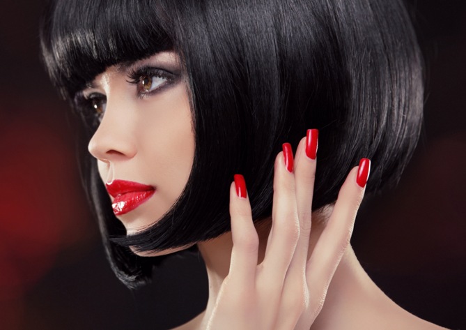 Brunette woman Portrait. Black short hair style. Manicured nails and red lips. Fashion Beauty Photo